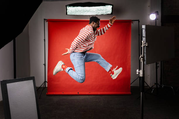 istock Cheerful black man jumping in a professional photo studio. 1469138470