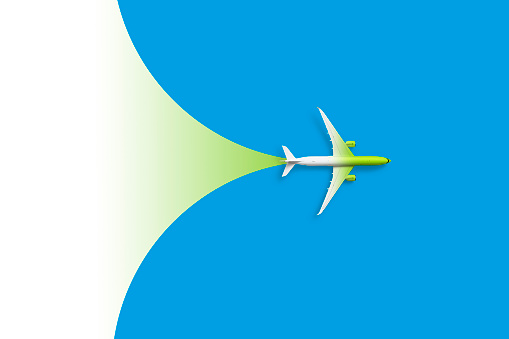 White modern passenger plane against blue and green background