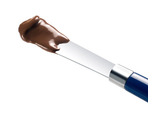 chocolate cream on knife isolated over white