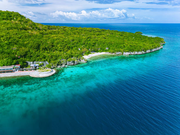 Drone shot of the island of Siquijor on a beautiful sunny day The beautiful island of Siquijor where the blue sky and turquiose water meet the lush green island. siquijor island stock pictures, royalty-free photos & images