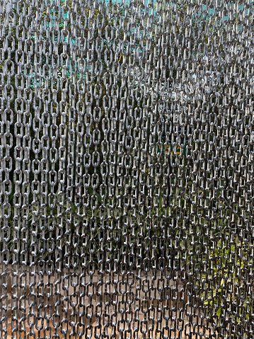 Stock photo showing close-up view of garden hanging rain chainlink curtain.