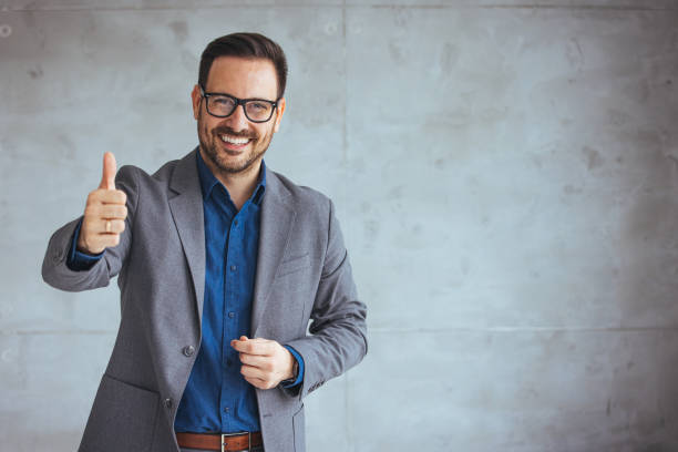 Businessman smiling with arms crossed on white background.