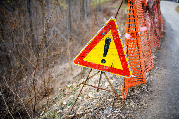 Warning sign collapsing road stock photo