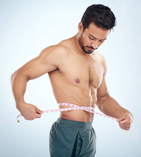 減量管理、脂肪管理またはbmiおよびダイエットの健康のためのスタジオ背景に男性、体または腰の巻尺。フィットネスモデル、スポーツアスリート、または筋肉目標の巻尺を持つコーチ - men muscular build abdominal muscle large ストックフォトと画像