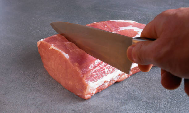 istock The chef is cutting fresh raw meat into steaks. Close-up on a gray background. 1469147318