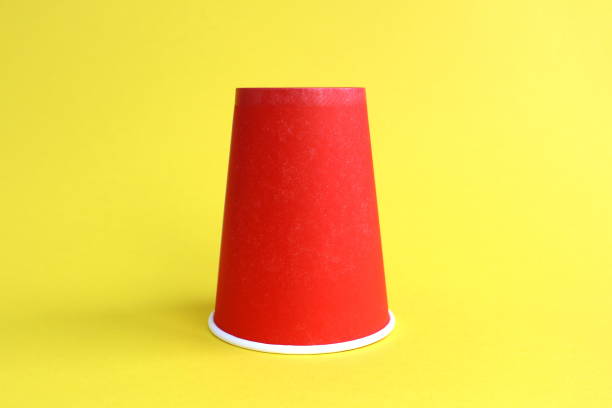 istock A red paper glass stands upside down on a yellow background. 1469147659