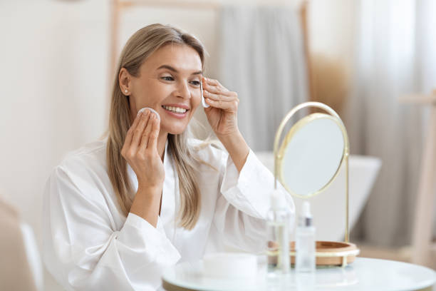 istock Smiling beautiful lady removing make up, using cotton pads 1469154368