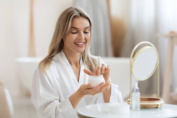 istock Attractive adult lady using hydrating face cream 1469154371