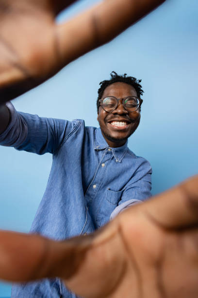 istock Happy black man having fun while taking a selfie against blue background. 1469154508