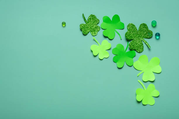 istock St. Patrick's Day minimalistic concept. Paper clover leaves on colored background with copy space 1469156313
