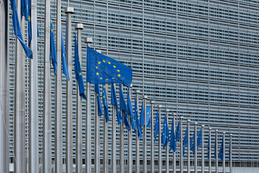 BRUSSELS, Belgium - February 23, 2023: Berlaymont building, seat of the European Commission, with flags blowing in the wind in front of it
