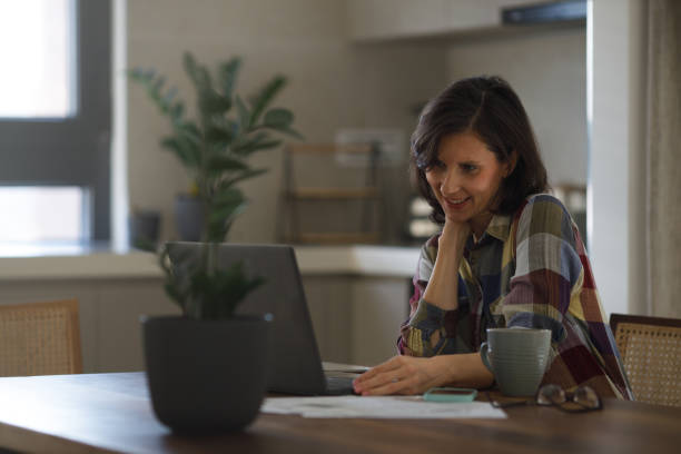 istock Woman using laptop while sitting at home 1469157184