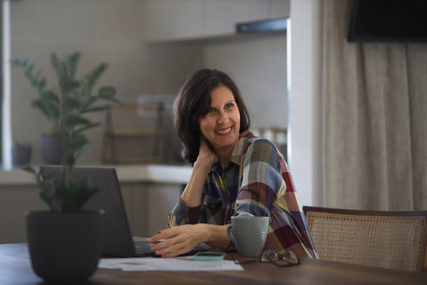 istock Woman using laptop while sitting at home 1469157206