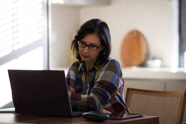 istock Woman using laptop while sitting at home 1469157307
