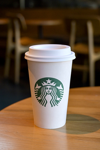 Austin, Texas - February 2023: Paper cup with Starbucks logo on a table in one of the company's chain of coffee shops