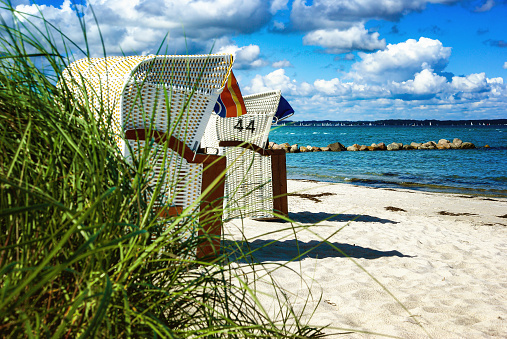Sandy coast with a cloudy summer sky and beach chairs