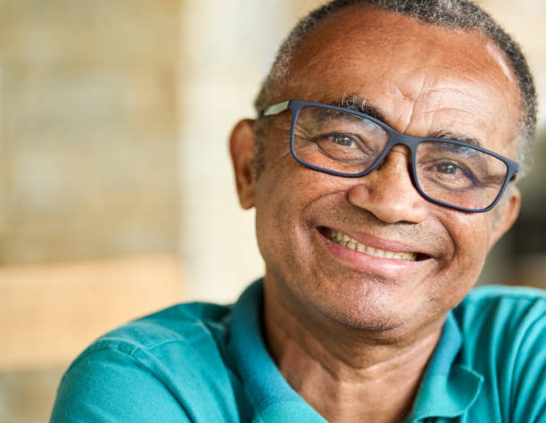 istock Mature man smiling while sitting outdoors on his patio at home 1469164884