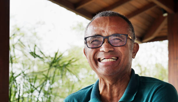 istock Mature man laughing while sitting outdoors on his patio at home 1469165238
