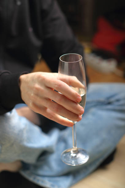 istock a person holding a glass with champagne 1469165938
