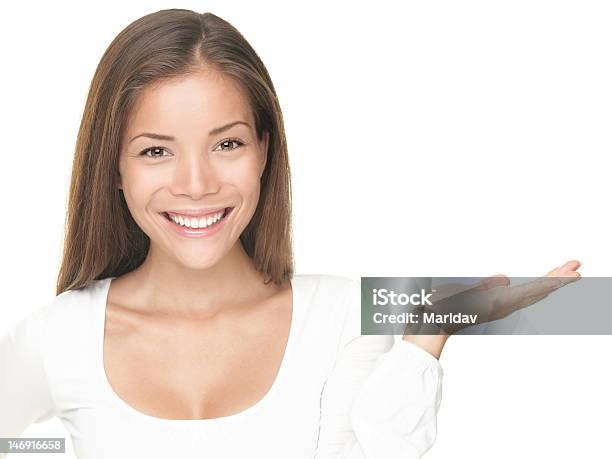 Smiling Young Woman With Open Hand To Show Something Stock Photo - Download Image Now