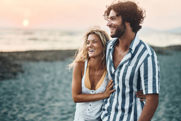 istock Happy couple walking embraced on the beach at sunset. 1469166593