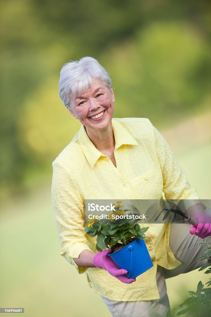 Mulher Madura trabalhando ao ar livre com flores - Foto de stock de 60 Anos royalty-free
