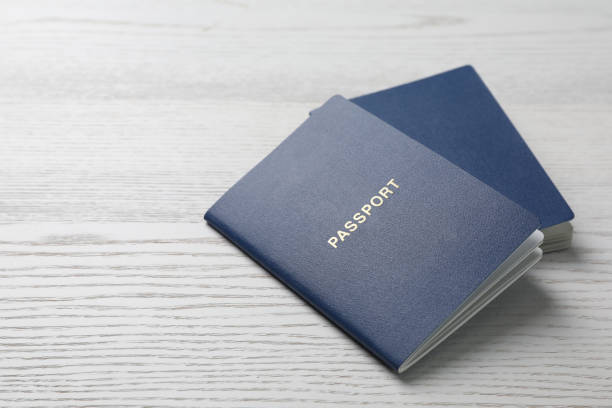istock Blank blue passports on white wooden table, closeup. Space for text 1469170685