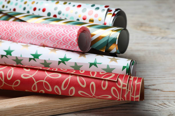 istock Different colorful wrapping paper rolls on white wooden table, closeup 1469171019