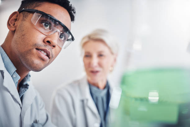 istock Face, doctors and beaker in laboratory for research, testing and analysis. Science, innovation and teamwork of man, senior woman and researchers with goggles looking at glass flask for experiment. 1469171063