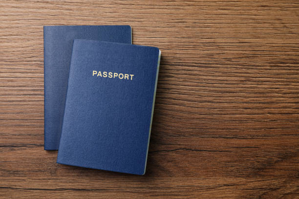 istock Blank blue passports on wooden table, flat lay with space for text 1469171548