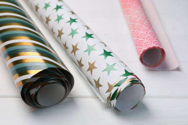 istock Different colorful wrapping paper rolls on white wooden table, closeup 1469172229