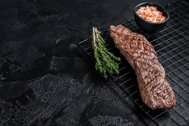 istock Grilled meat steak Machete skirt on a rack. Black background. Top view. Copy space 1469173906