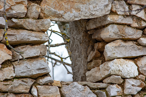 A window in the stone wall of an old ruined house in an abandoned village