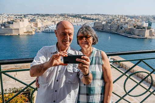 Beautiful senior tourist couple taking a selfie at a high point  in Valletta, Malta.