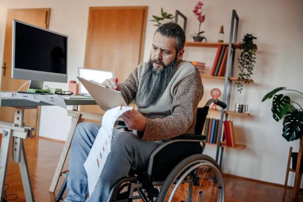 istock Man in wheelchair working from home 1469179703