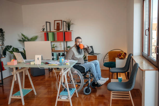 istock Man in wheelchair working from home looking at camera 1469179773
