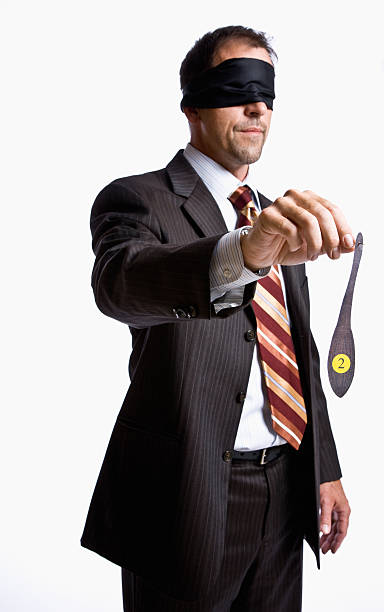 Businessman in blindfold holding donkey tail. Vertical shot.