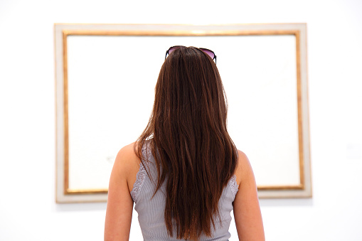 Woman looking at art painting in museum - blank canvas. Click for more: