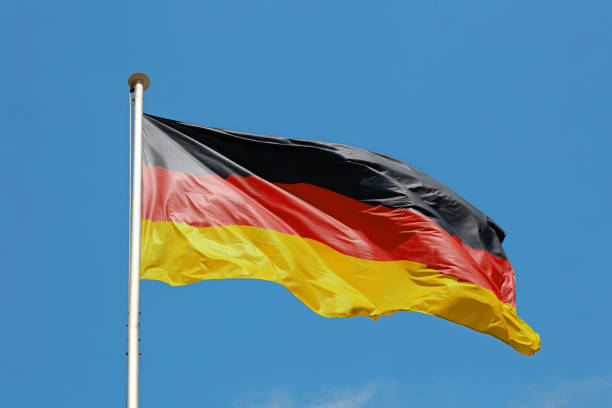 istock German flag waving in cloudy blue sky 1469185140