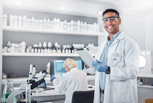 Ciencia, tableta y retrato de un científico que investiga con tecnología en un laboratorio médico. Feliz, sonríe y hombre químico o biólogo trabajando en un dispositivo móvil en un laboratorio farmacéutico. photo