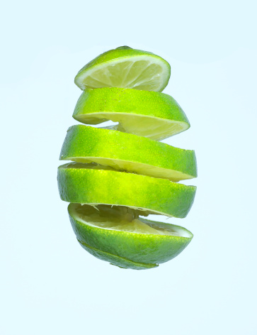 a lime spiralled suspended mid air with a light blue background