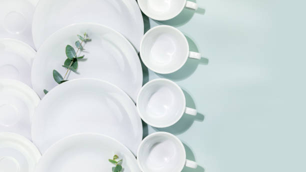 istock Empty dishes and cups with eucalyptus twigs on blue background with copy space 1469187240