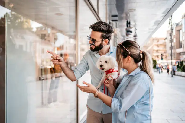 Photo of Young Couple Window Shopping With Their Dog