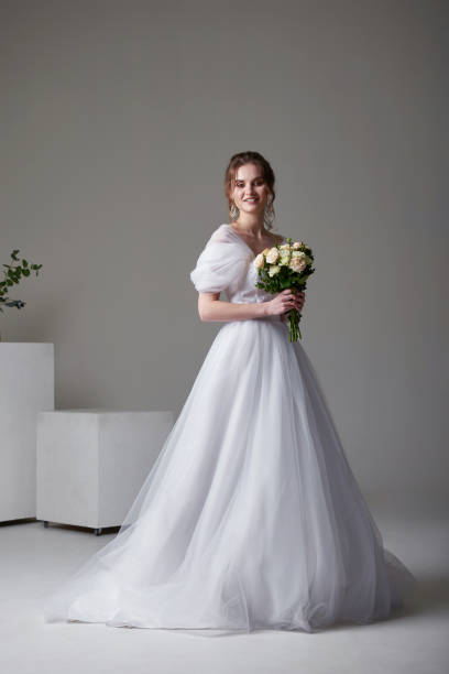 istock A beautiful young bride model in long lace dress in minimalist white studio interior. Wedding photography. 1469193343