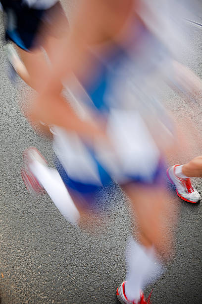 A full length studio shot of an athlete wearing a number pinned to his shirt and running towards the camera