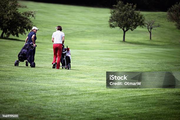 Donna Camminare Sul Campo Da Golf Con Carrelli - Fotografie stock e altre immagini di Donne - Donne, Golf, Adulto