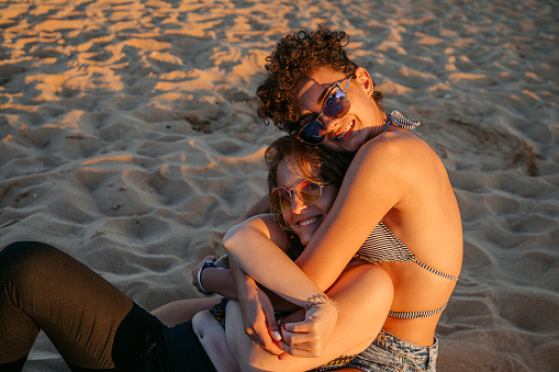 Portrait of a beautiful young lesbian couple embracing on the beach in Albena, Bulgaria.