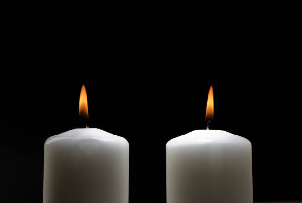 istock two white candles with flame isolated on black background ,couple 1469200832