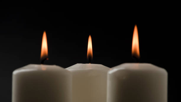 istock set of three burning candles on a black background 1469200894