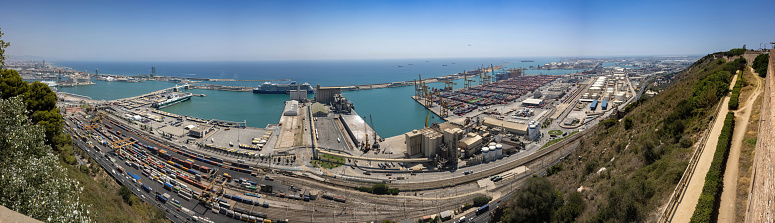 Barcelona, Spain - July 21, 2022: The cargo and cruise ship terminals with moored ships and containers.